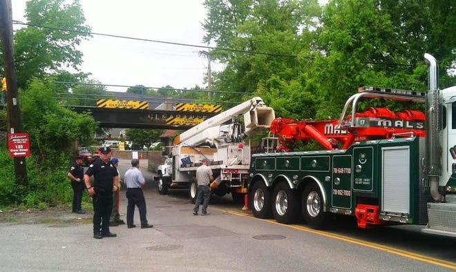 Bucket truck trapped under a low clearance bridge